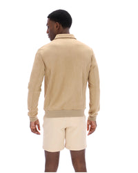 Man wearing a beige jacket and cream shorts on a white background