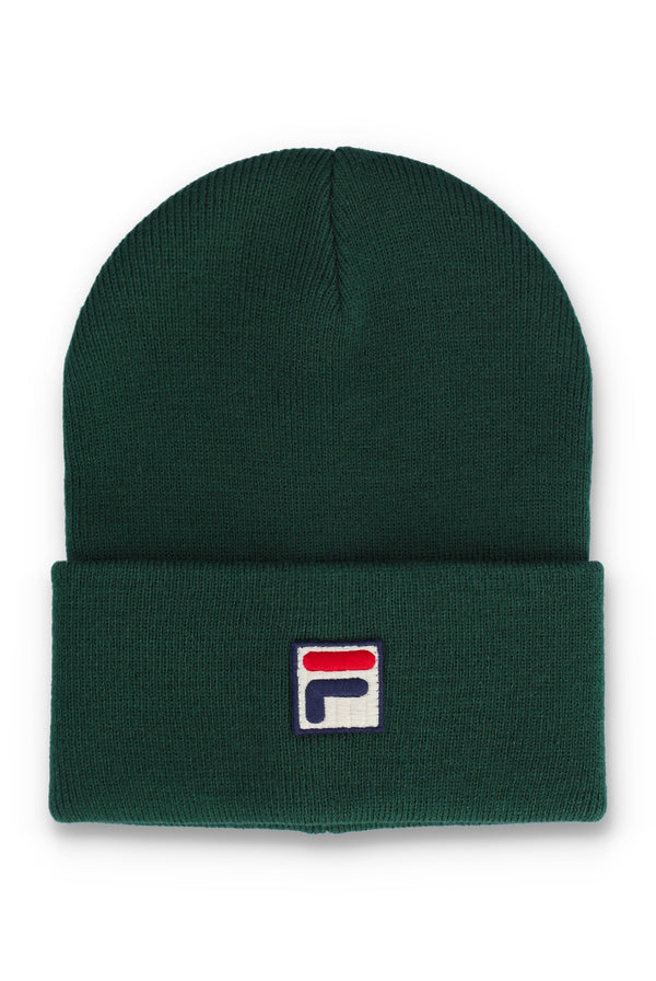 A dark green ribbed knit beanie hat with a folded cuff, featuring a small embroidered Fila logo patch on the front.