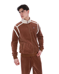Man wearing a brown tracksuit with white accents on a white background