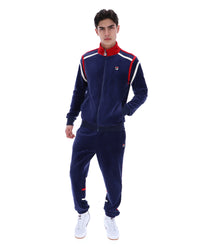 Man wearing a navy tracksuit with red and white accents, with a FILA logo on the chest, paired with matching bottoms, against a white background