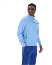 Man wearing a light blue sweater and blue pants on a white background