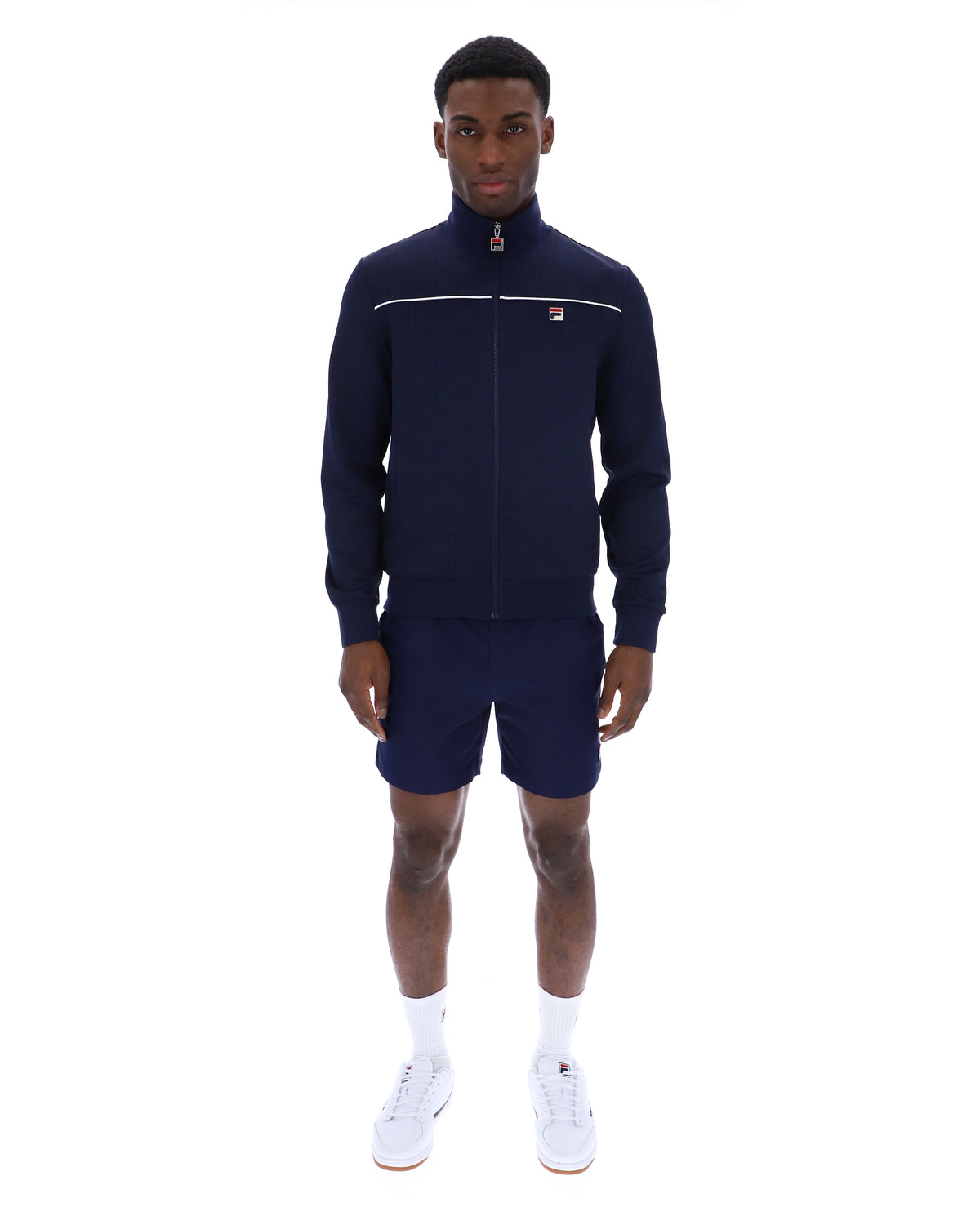 Man wearing a navy tracksuit with a white logo on a white background