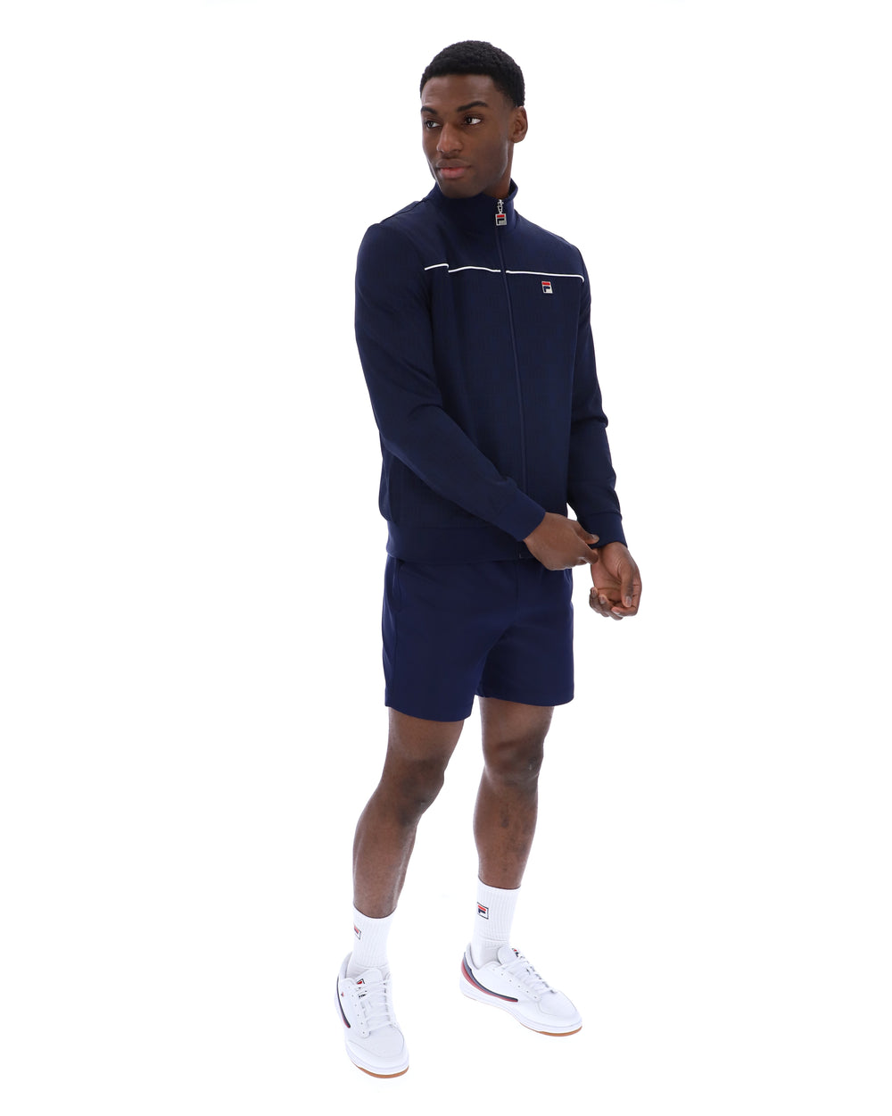 Man wearing a navy tracksuit with a white logo on a white background
