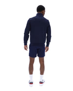 Man wearing a navy tracksuit on a white background