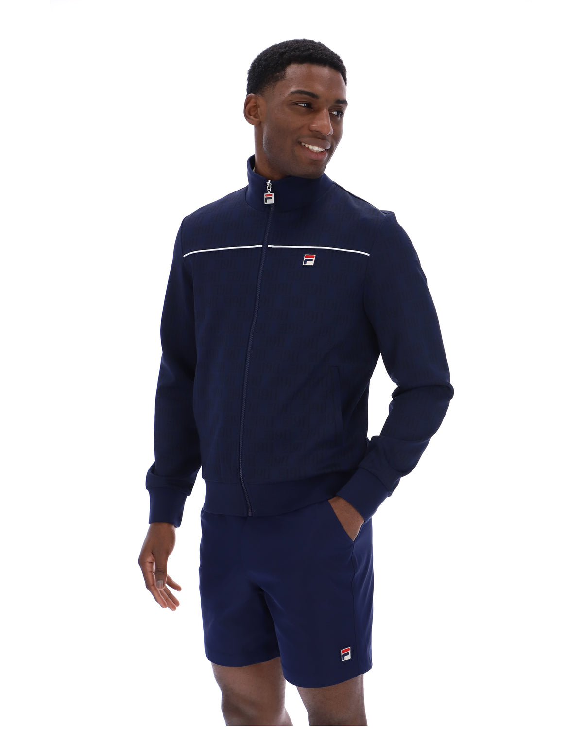 Man wearing a navy tracksuit with a brand logo on a white background