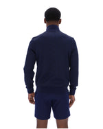 Person wearing a navy blue tracksuit on a white background