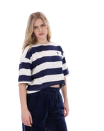 Woman wearing a navy and white striped sweater with a logo on a white background