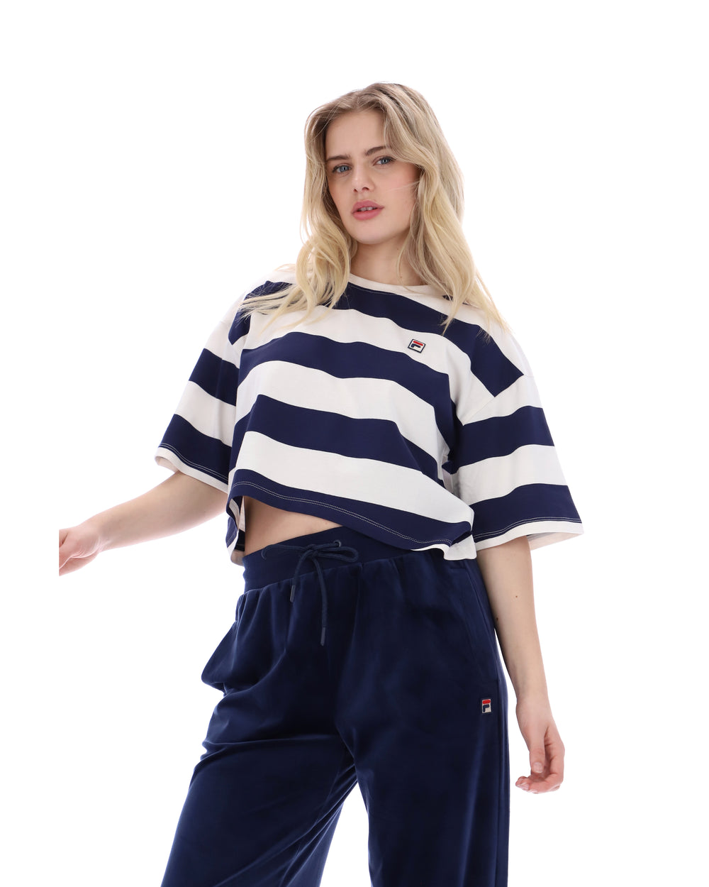 Woman wearing a navy and white striped crop top with matching pants on a white background