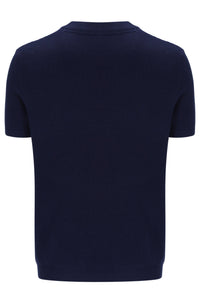 Man wearing a Navy blue t-shirt with white and red stripes and Fila logo with matching joggers on a white background