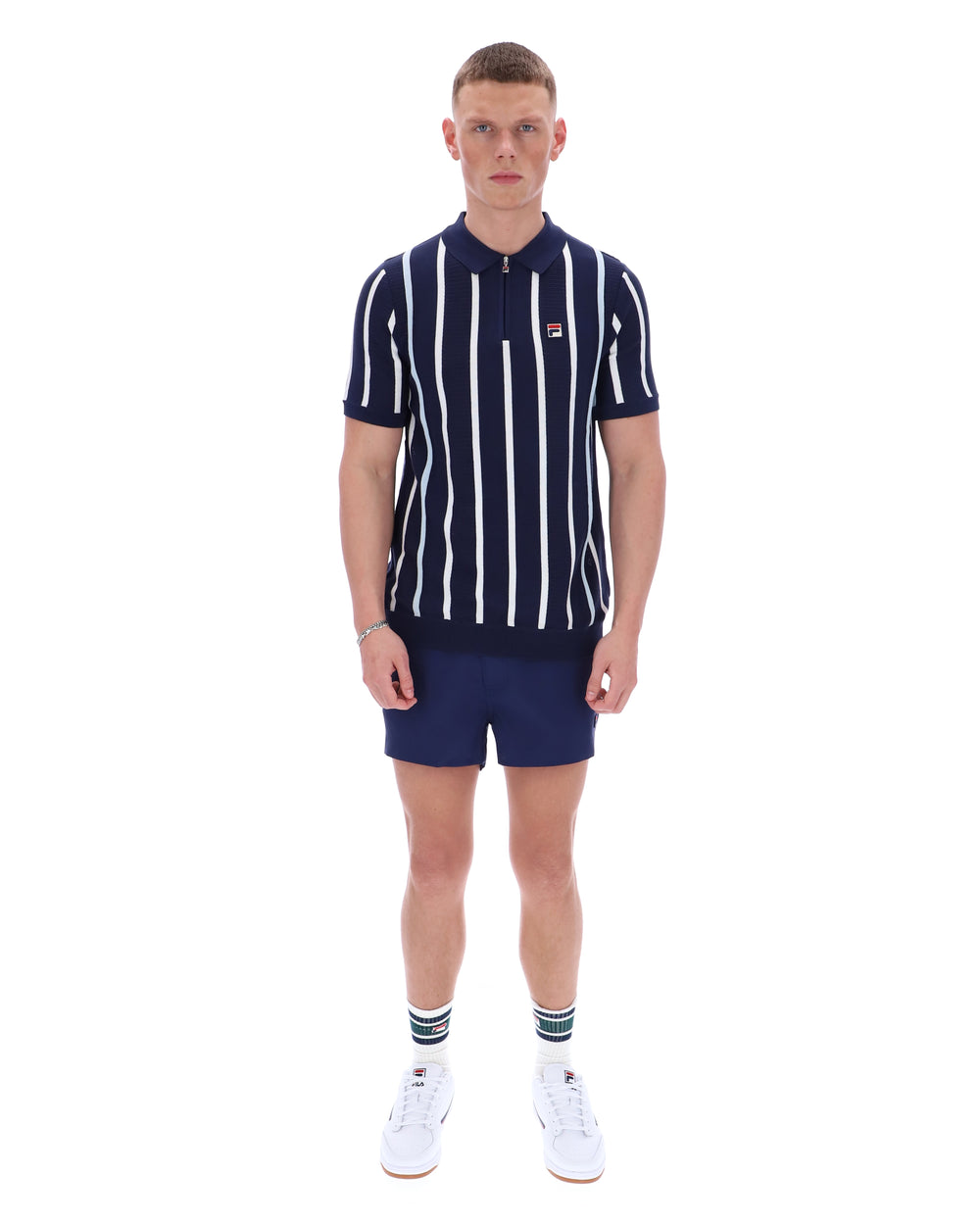 Man wearing a navy and white striped polo shirt with matching shorts on a white background