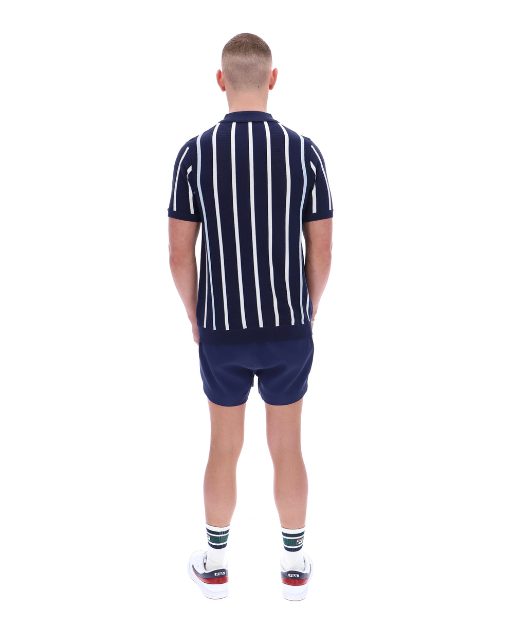 Person wearing a navy and white striped shirt and shorts set on a white background