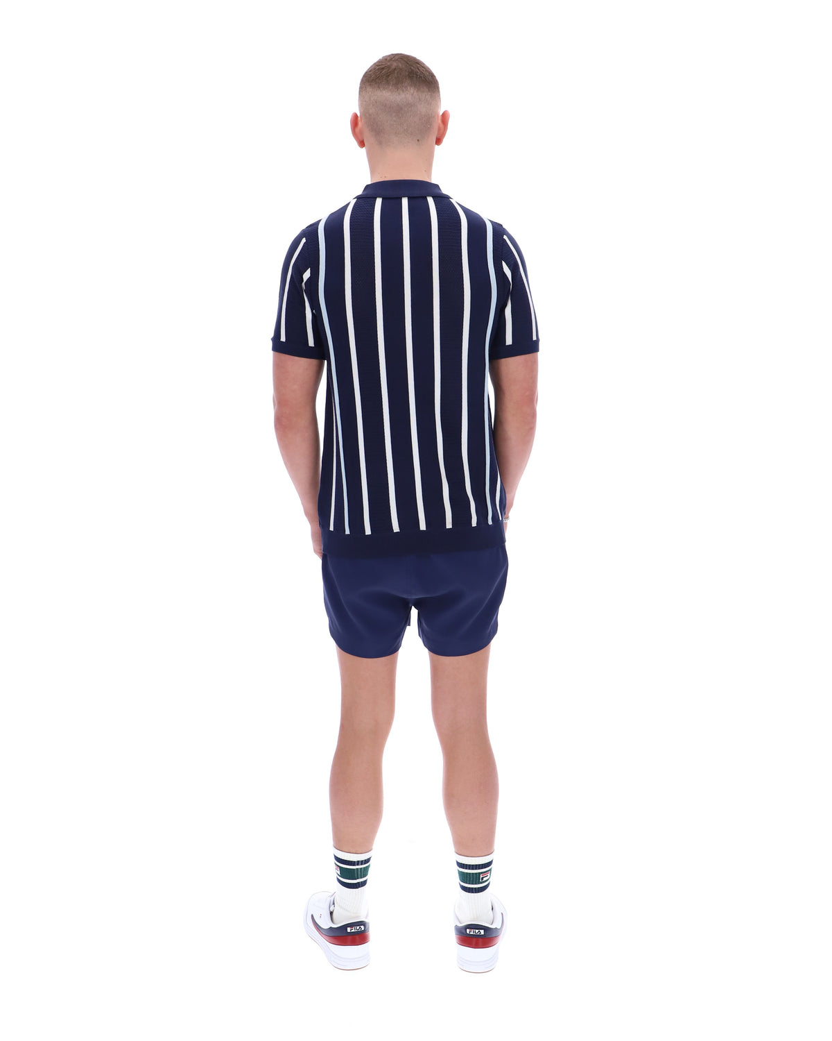 Person wearing a navy and white striped shirt and shorts set on a white background
