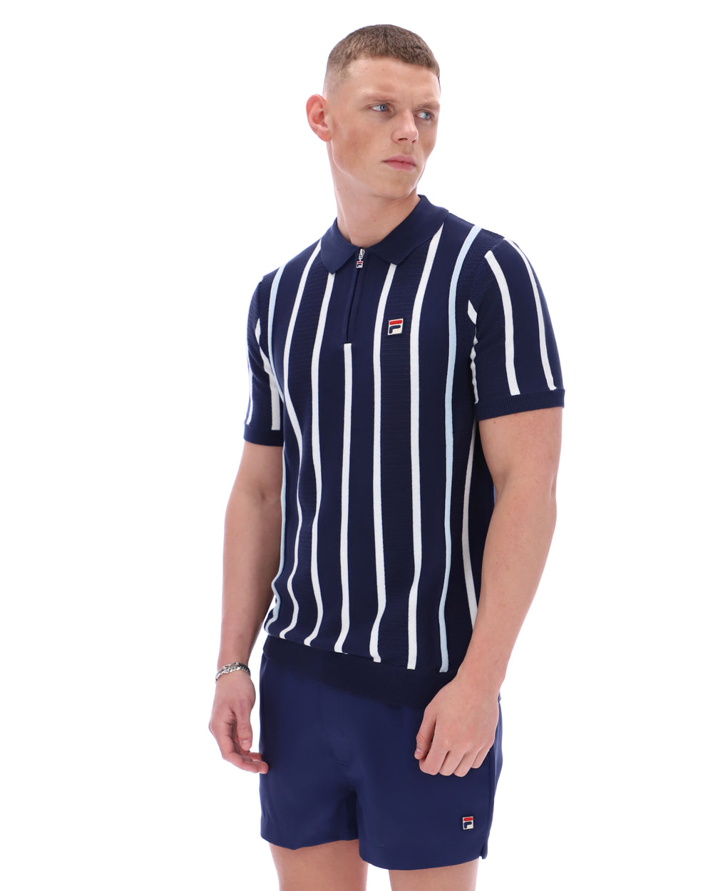 Man wearing a navy and white striped polo shirt with matching shorts on a white background