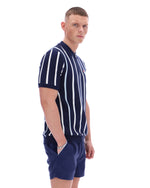 Man wearing a navy and white striped polo shirt with matching shorts on a white background