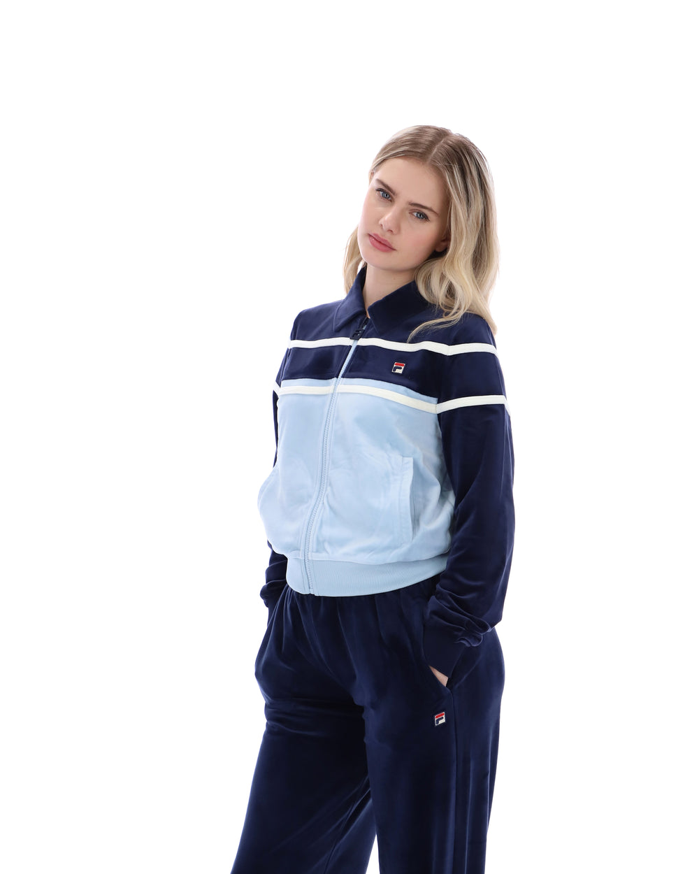 Woman wearing a blue tracksuit with white stripes on a white background
