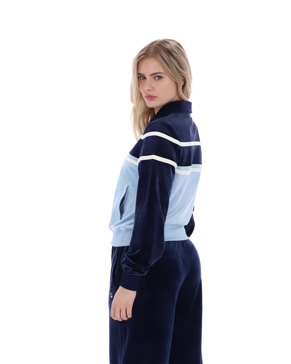 Woman wearing a navy and light blue tracksuit on a white background
