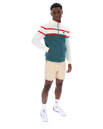Man wearing a green and white track top with red detailing, with a FILA logo on the chest, paired with beige FILA shorts, against a white background