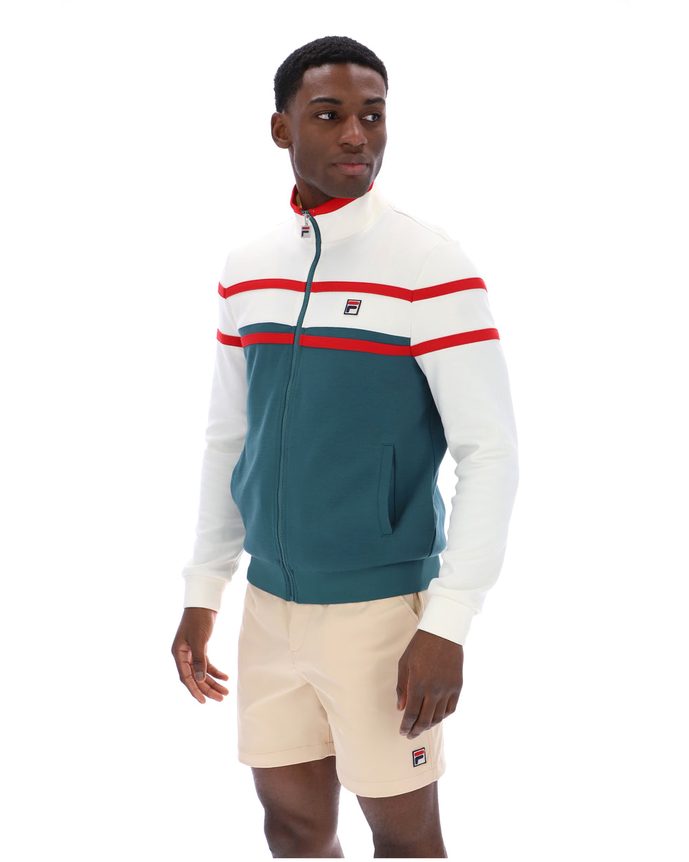 Man wearing a green and white track top with red detailing, with a FILA logo on the chest, paired with beige FILA shorts, against a white background