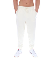 White sweatpants with a FILA logo worn by a person on a white background