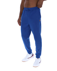 Blue sweatpants worn by a person on a white background