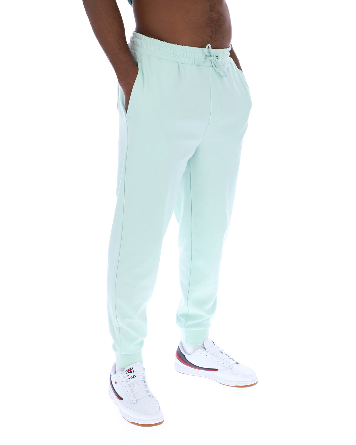 Light green jogger pants worn by a person on a white background