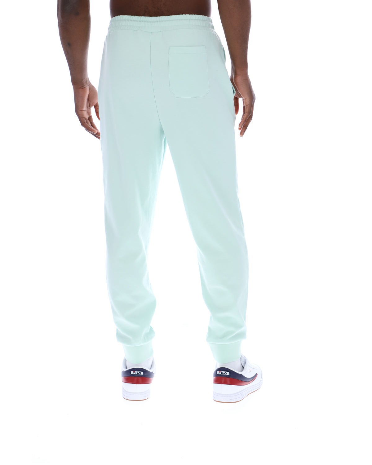 Light green sweatpants worn by a person on a white background