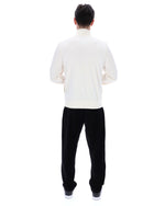 Person wearing a white shirt and black pants on a white background