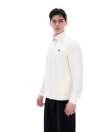 Person wearing a white long-sleeve shirt with a small logo on a white background
