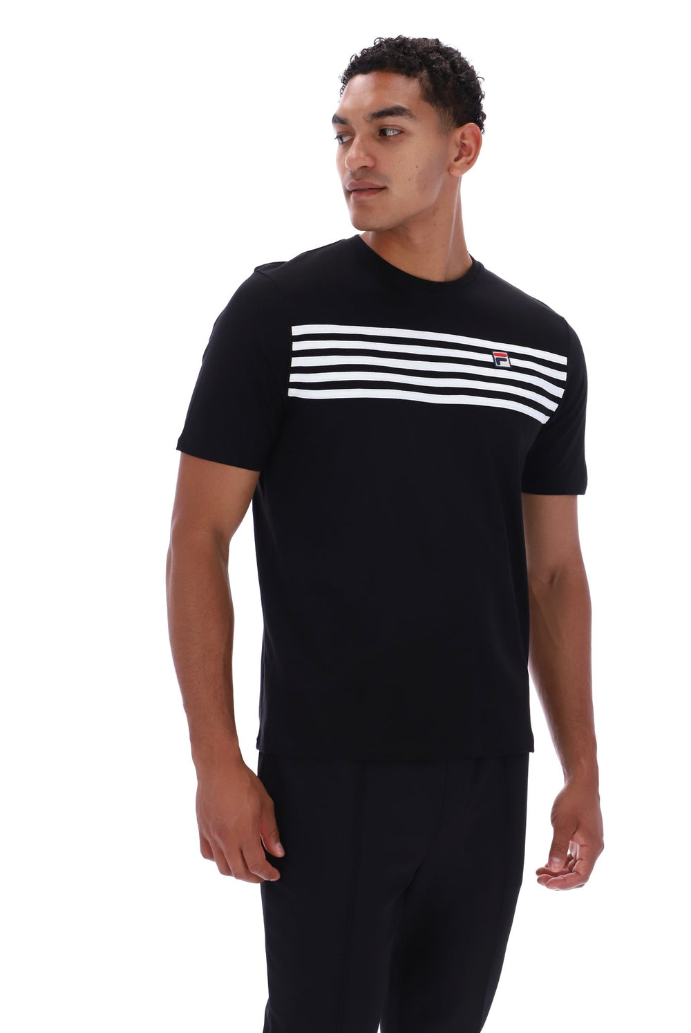 A man wearing a black short-sleeve crewneck t-shirt with a horizontal white stripe pattern across the chest and a small red and white logo on the right chest, paired with black pants, against a plain white background.