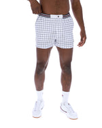 Person wearing white checkered shorts on a white background