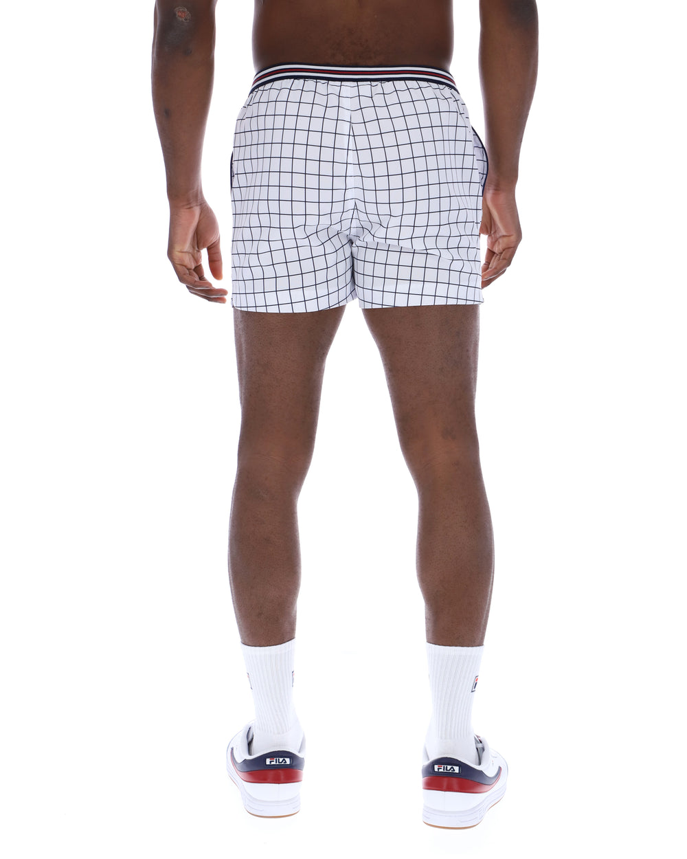 Person wearing black and white checkered shorts on a white background