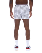 Person wearing black and white checkered shorts on a white background