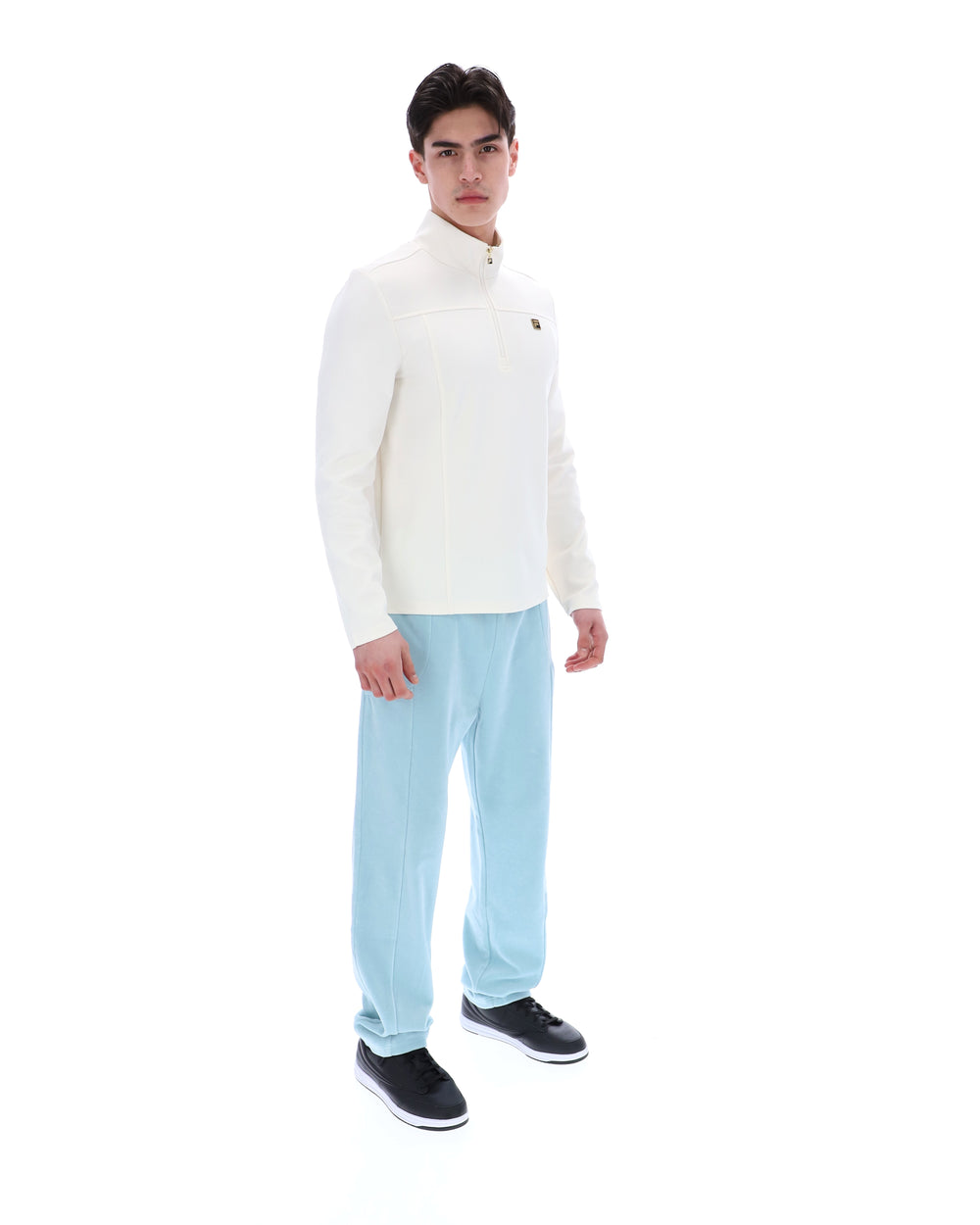 Person wearing a white sweater and light blue pants on a white background