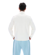 Person wearing a white jumper and light blue pants on a white background