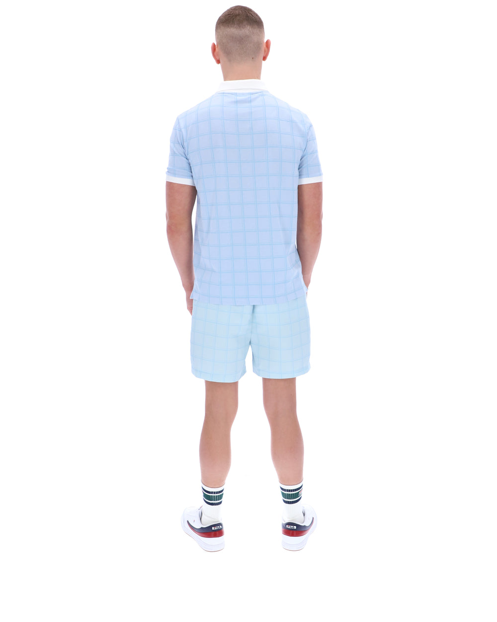 Person wearing a light blue checkered outfit on a white background