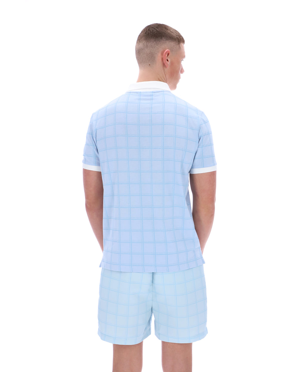 Man wearing a light blue checkered shirt and shorts set on a white background