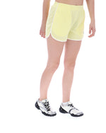 Person wearing yellow mesh shorts and white sneakers on a white background