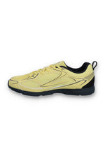 Yellow athletic shoe with black sole on a white background