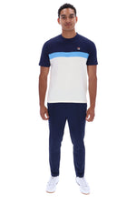 A man modeling a short-sleeve colorblock t-shirt and matching navy pants. The t-shirt features a navy blue upper section, a light blue horizontal stripe across the chest, and a large white block on the lower half.