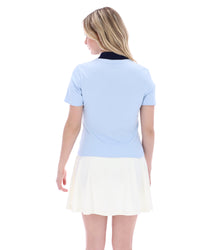 Woman wearing a light blue top and white skirt on a white background