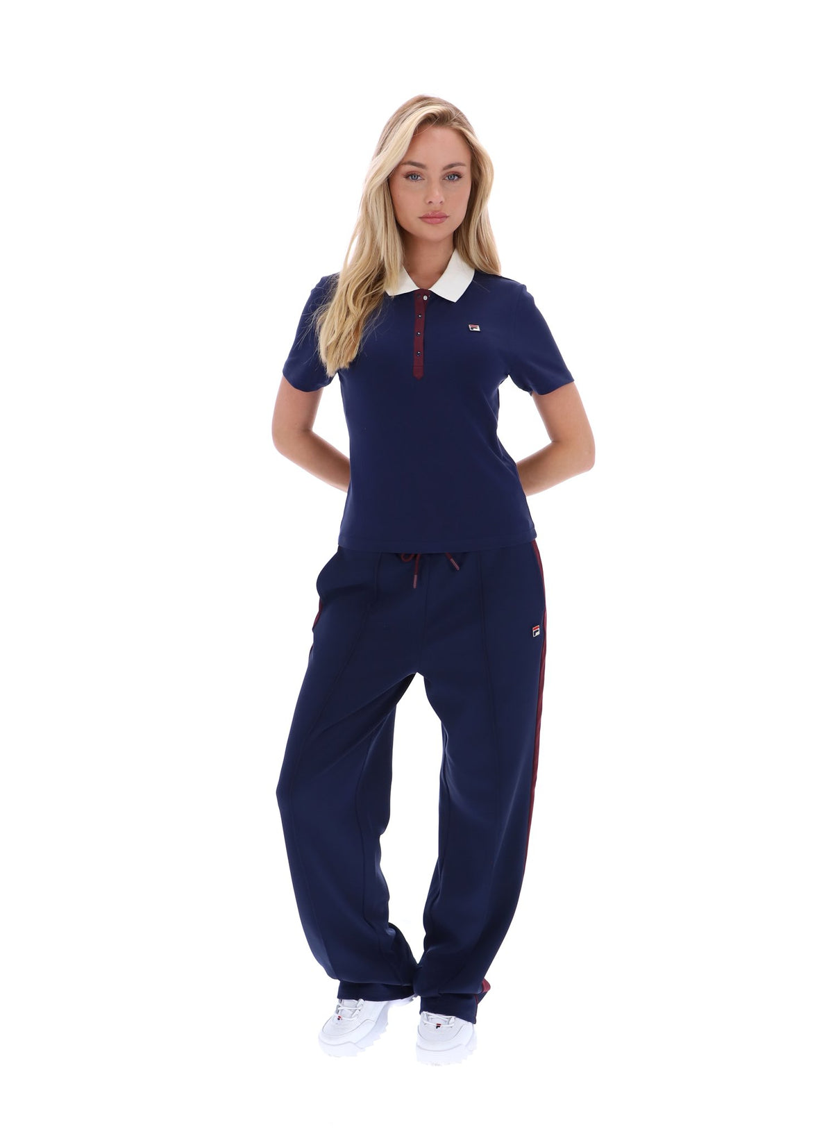 Displays a model wearing the Navy 'FILA' branded Juno Fitted Iconic Polo