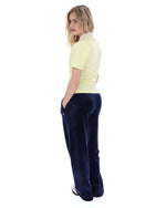 Woman wearing a yellow polo shirt and navy blue pants on a white background