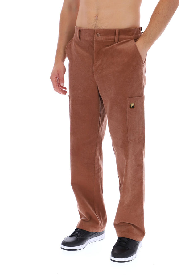 A person modeling a pair of brown corduroy cargo pants with black sneakers, shown from the waist down against a plain white background.