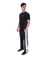 Man wearing a black t-shirt and black pants with white stripes on a white background