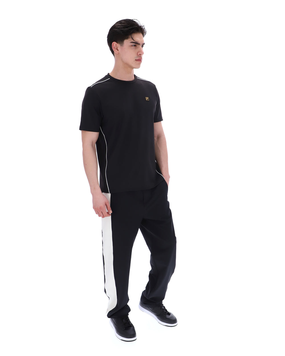 Man wearing a black outfit with white accents on a white background