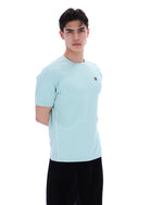 Man wearing a light blue athletic shirt and black shorts on a white background
