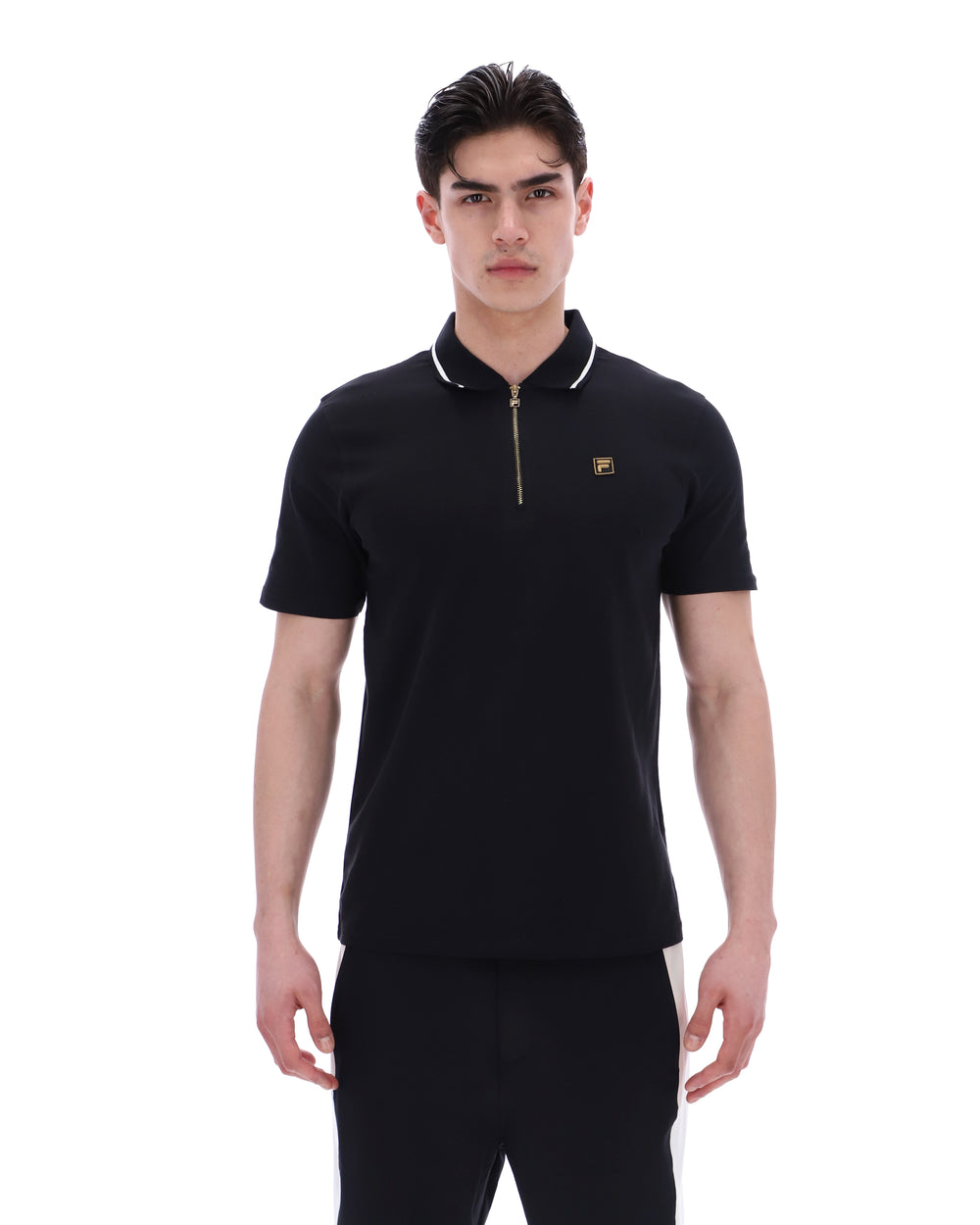 Man wearing a black polo shirt with a small logo on a white background