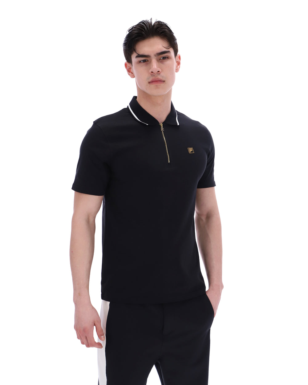 Man wearing a black polo shirt with a small logo on a white background