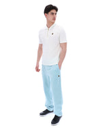 Man wearing a white polo shirt and light blue pants on a white background