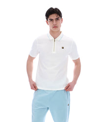 Man wearing a white polo shirt and light blue pants on a white background